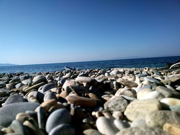 Rocks in sea against clear sky