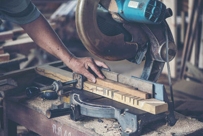 Cropped hand of manual worker working in factory