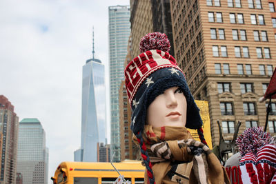 Portrait of young woman against modern buildings in city