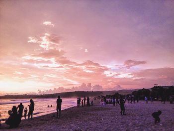 People at beach during sunset