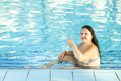 Smiling woman in the pool shows class. horizontal photo