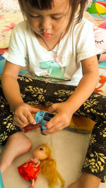 High angle view of cute girl playing with toys at home