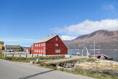 Road by buildings against sky in city