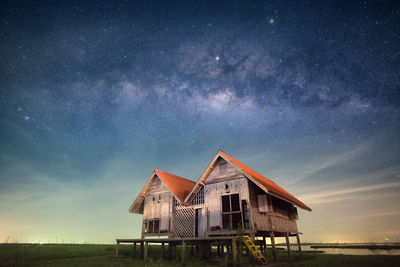 Wooden houses at lakeshore against sky