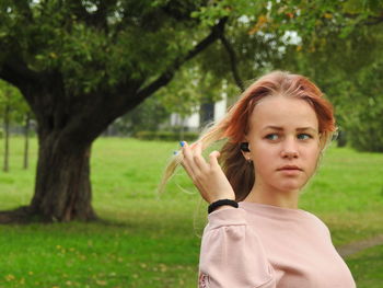 Girl looking away while standing in park