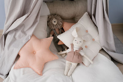 Various pillows. square and sprocket, soft toys on the children's bed