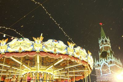 Low angle view of illuminated carousel at night
