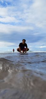 Man in sea against sky