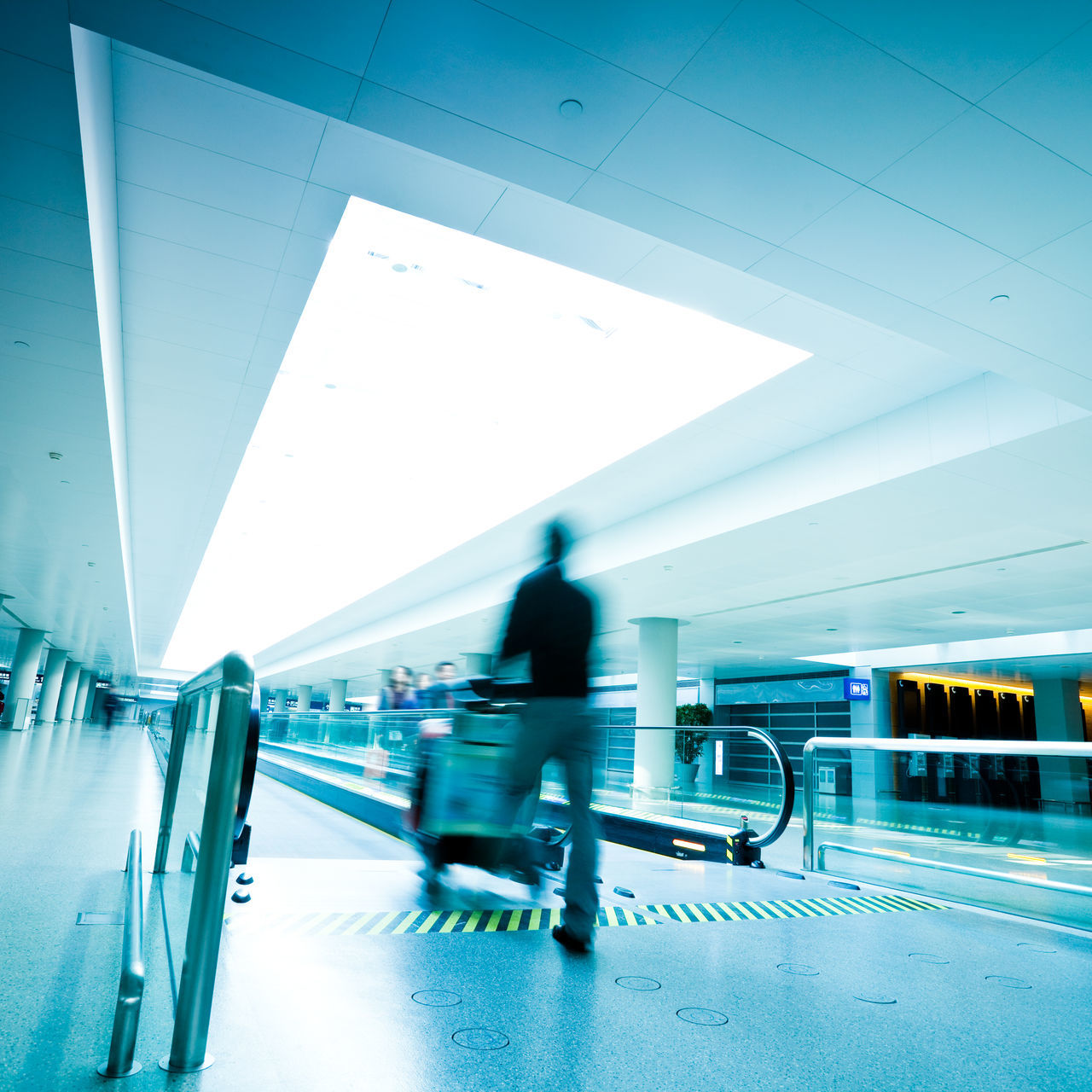 BLURRED MOTION OF MEN WALKING IN AIRPORT