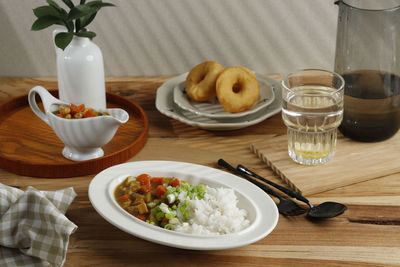 Breakfast with japanese curry, rice, lemon water, and donut. concept asian breakfast