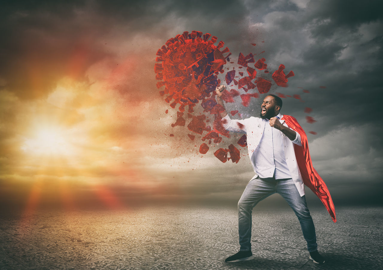 DIGITAL COMPOSITE IMAGE OF MAN HOLDING UMBRELLA AGAINST SKY