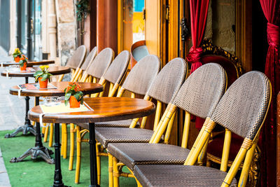 Empty tables and chairs at sidewalk cafe