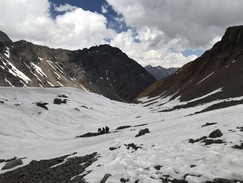 Scenic view of mountains against cloudy sky during winter