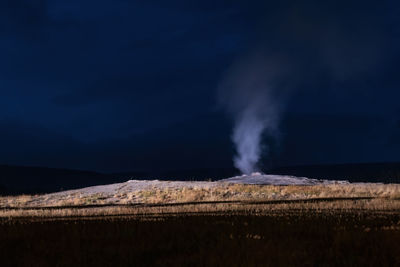 Smoke emitting from land against sky at night