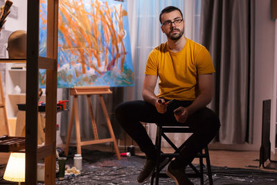 Young man sitting on chair at home