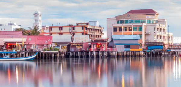 Boat moored in lake by buildings