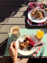 Midsection of woman holding coffee cup on table