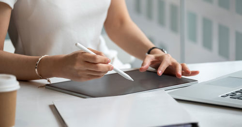 Midsection of woman holding paper with text