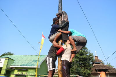 Low angle view of people against clear sky