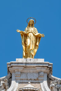 Low angle view of statue against blue sky