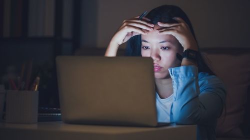 Portrait of teenage girl using mobile phone at home