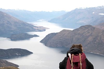 Person with backpack against river and mountains