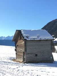 Built structure on snowcapped mountain against sky