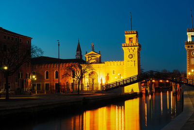 Illuminated buildings against sky at night