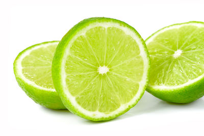 Close-up of green fruit against white background