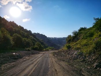 Road amidst trees against sky