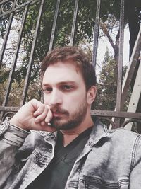 Portrait of young man against trees