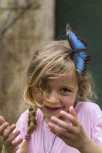 Portrait of smiling girl with butterfly on her head