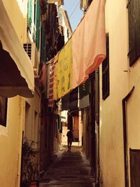 Man walking in alley amidst buildings