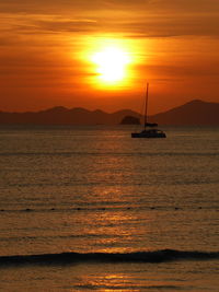 Silhouette of boat sailing in sea during sunset