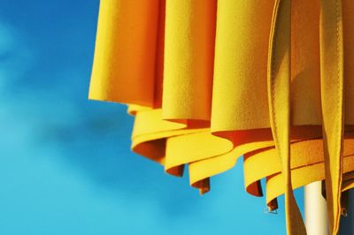 Cropped image of yellow beach umbrella against sky