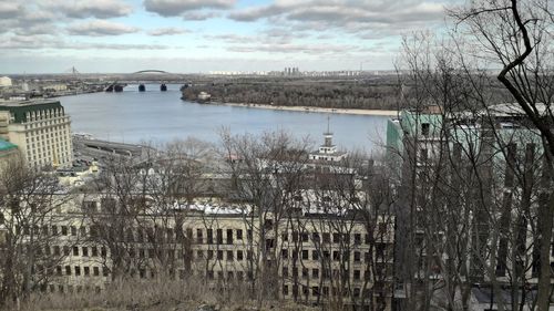 Scenic view of river by buildings against sky