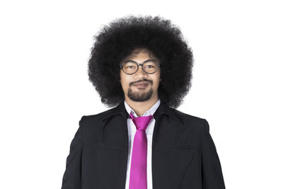 Portrait of young man standing against white background