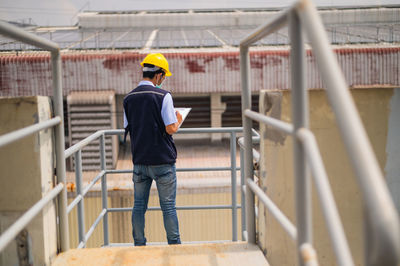 Full length of man working on railing