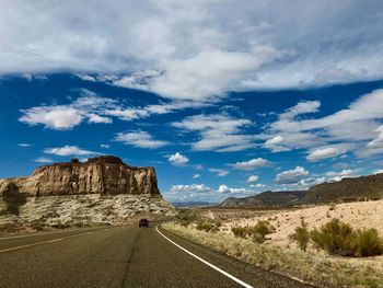 Road leading towards mountains against sky