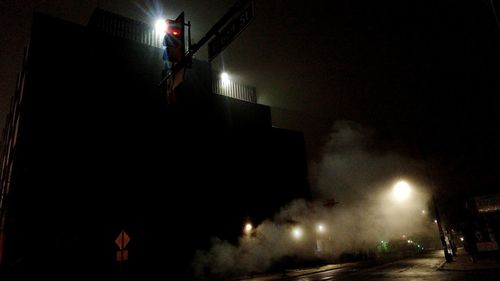 Illuminated street light against sky at night