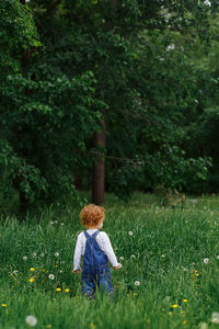 Rear view of little girl  on field