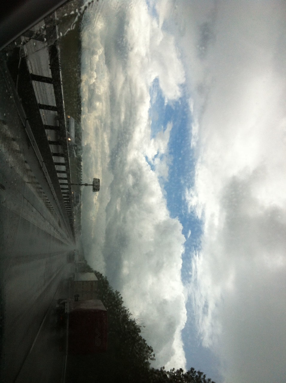 sky, cloud - sky, architecture, built structure, building exterior, transportation, cloudy, mode of transport, high angle view, cloud, weather, city, road, outdoors, day, on the move, the way forward, building, overcast, low angle view