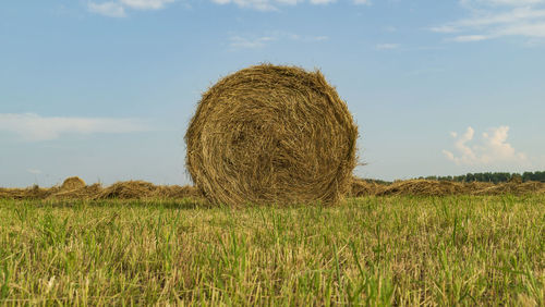 Hay bales on field against sky