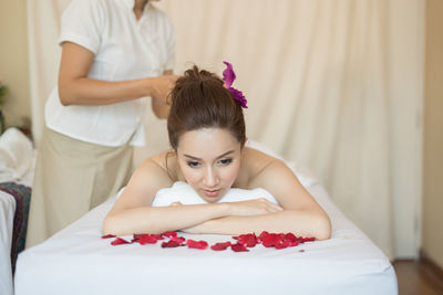 Masseur massaging young woman on table in spa