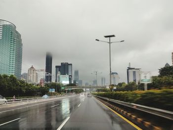 Street amidst buildings against sky in city