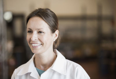 Happy female engineer looking away in industry