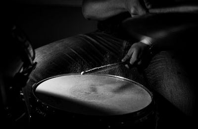 Close-up of man playing drum in darkroom