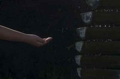 Cropped image of hand by falling water