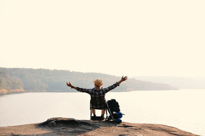 Full length and rear view of man by lake