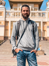 Portrait of man standing against built structure